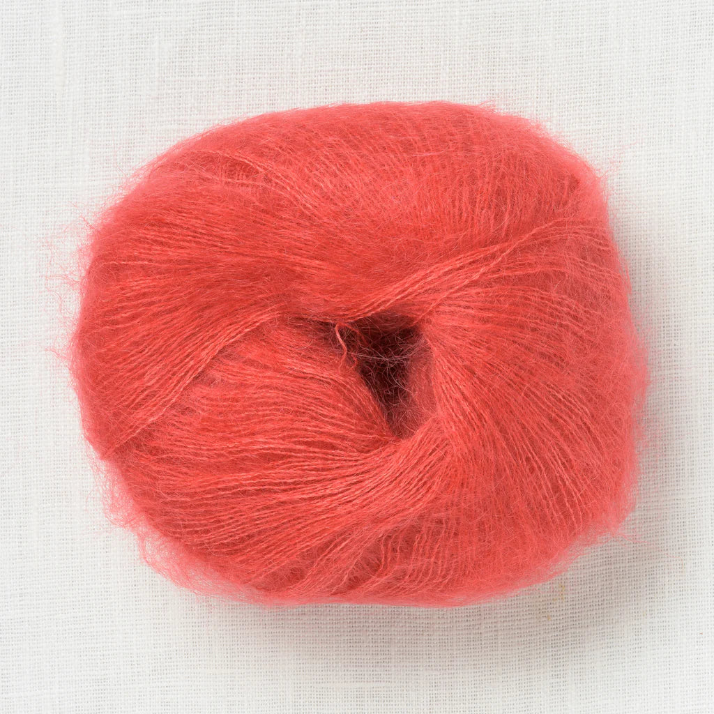 A fluffy ball of light electric reddish orange yarn.