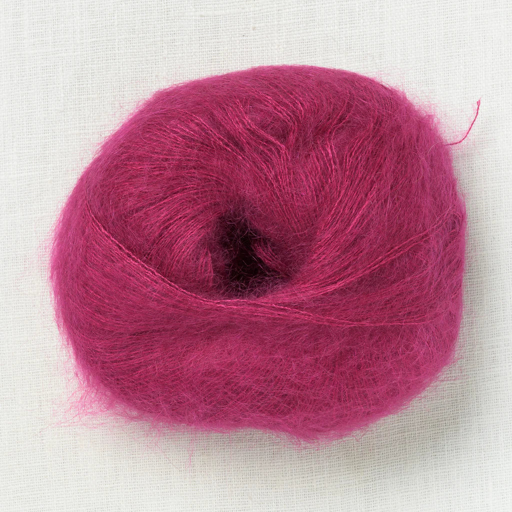 A fluffy ball of berry pink colored yarn