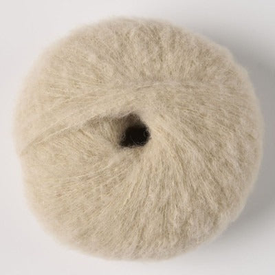 Ball of beige fluffy alpaca yarn.