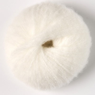Ball of cream white fluffy alpaca yarn.