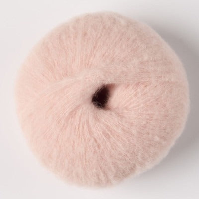A ball of light pink fluffy alpaca yarn.