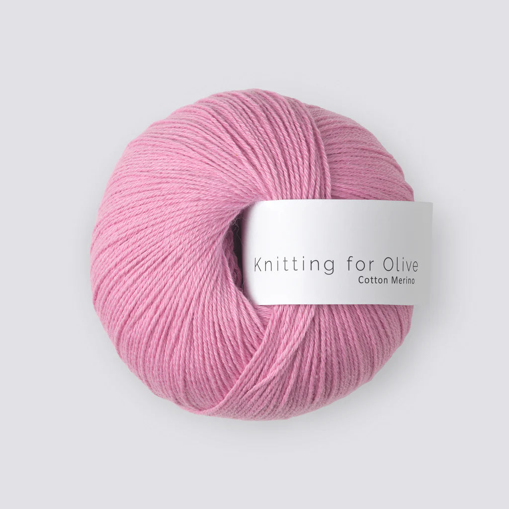 A ball of bubblegum pink yarn with a white 'Knitting for Olive' label, on a white background. 