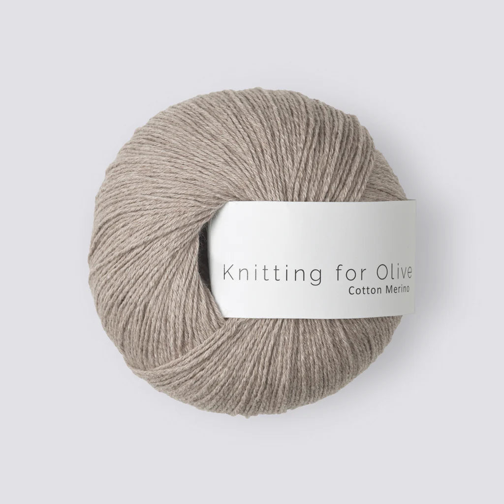 A ball of oatmeal yarn with a white 'Knitting for Olive' label, on a white background. 