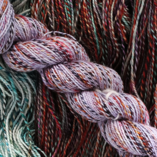 Close-up of braided yarn skeins in a variegated malabrigo Torzel colorway.